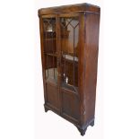 An early 20th century oak glazed bookcase on bracket feet (lacking interior shelves).