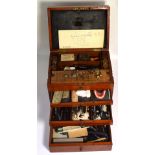 An early 20th century six drawer mahogany dentist portable cabinet complete with dentists tools and