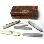 A small wooden box containing six penknives to include a silver and mother of pearl example.