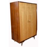 A retro 1960s twin door wardrobe on tapering block supports with integral section for shirts,