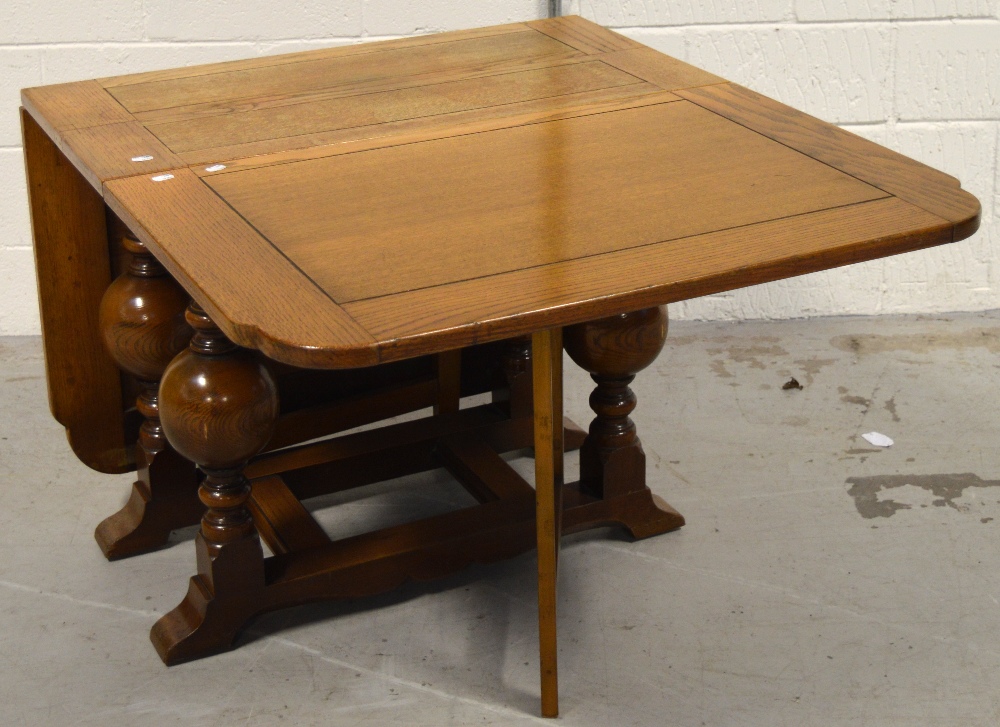 A mid 20th century oak drop leaf dining table on baluster supports, length 164cm.