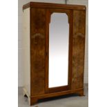 An early to mid 20th century walnut double mirror door wardrobe,