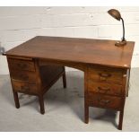 A 20th century oak desk with six drawers on block supports,