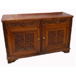 A 20th century oak carved sideboard, two drawers over two cupboard doors,