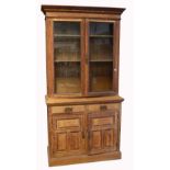 An Edwardian two door glazed bookcase over a cupboard with two drawers over two cupboard doors with