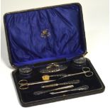 A cased manicure set comprising silver handle manicure items,