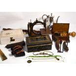 A vintage suitcase containing a quantity of collectibles to include a sewing machine,