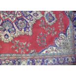 A red ground Turkish rug, approx 350 x 210cm.