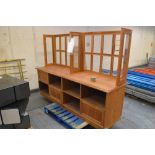 A walnut veneered double section shop unit with glazed upper section set with brackets for shelves,