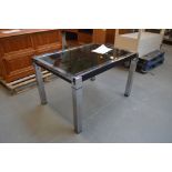 A chromed breakfast table of rectangular form with smoked glass inset and square section legs,