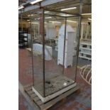 A brass framed shop display unit with glazed top, back and sides and open front,