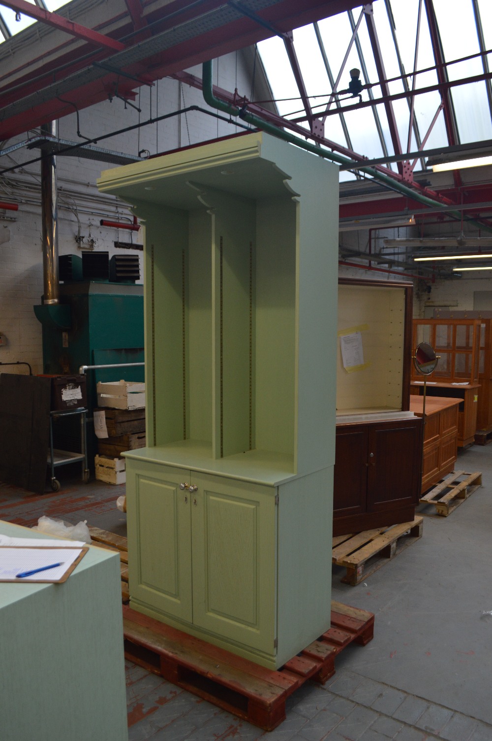 A pale green stained bookcase on cupboard,