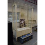 A large painted shop unit with moulded cornice above glazed ends, open fronted back,