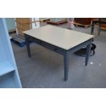A cream and grey painted three drawer kitchen table raised on square section tapering legs,