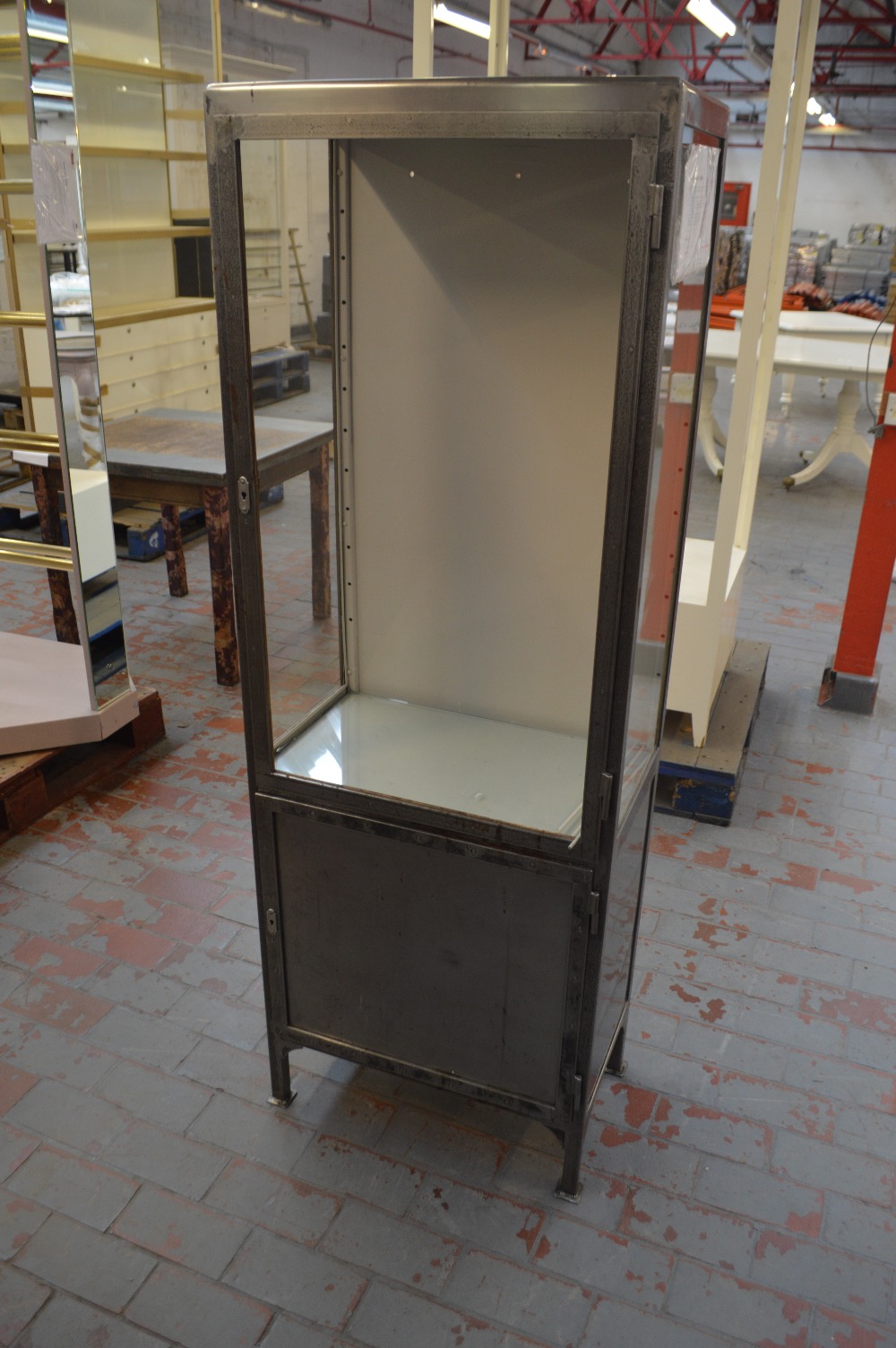 A small display cabinet with polished metal frame, glazed sides and cupboard door to base,