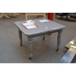 A grey painted dining table, with rectangular top with canted corners,