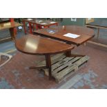 A two-leaf extending dining table with rounded rectangular top raised on shaped end supports to