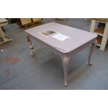 A pale pink painted display or centre table with rounded rectangular top above cabriole legs and