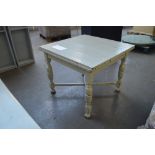A painted drawleaf table raised on turned and block supports.