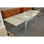 A pale green painted French style dining table with additional end drawer leaves and cabriole legs