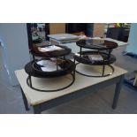 Four circular metal framed occasional tables with black perspex tops, diameter from 50cm to 65cm.