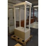 A white painted shop display unit with glazed sides, open back and front and cupboard door to base,