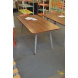 A contemporary dining table with rounded rectangular wooden top above metal base with four square
