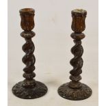 A pair of early 20th century carved oak barley twist candlesticks, height 34cm.