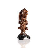 A CARVED WOOD FIGURE OF AN IMMORTAL WITH PEACHES OF LONGEVITY
China, Qing dynasty (19th century).
