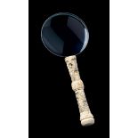 ? A MAGNIFYING GLASS WITH CARVED IVORY HANDLE
China, late Qing dynasty. Length 28.5 cm.
(CITES