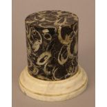 Marble base in the form of a cylindrical collumn, black marble with lots of fossil inclusions, on