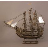 Large silver ship or galleon with ten cannons, seals, strings, boat; silver chased and partly