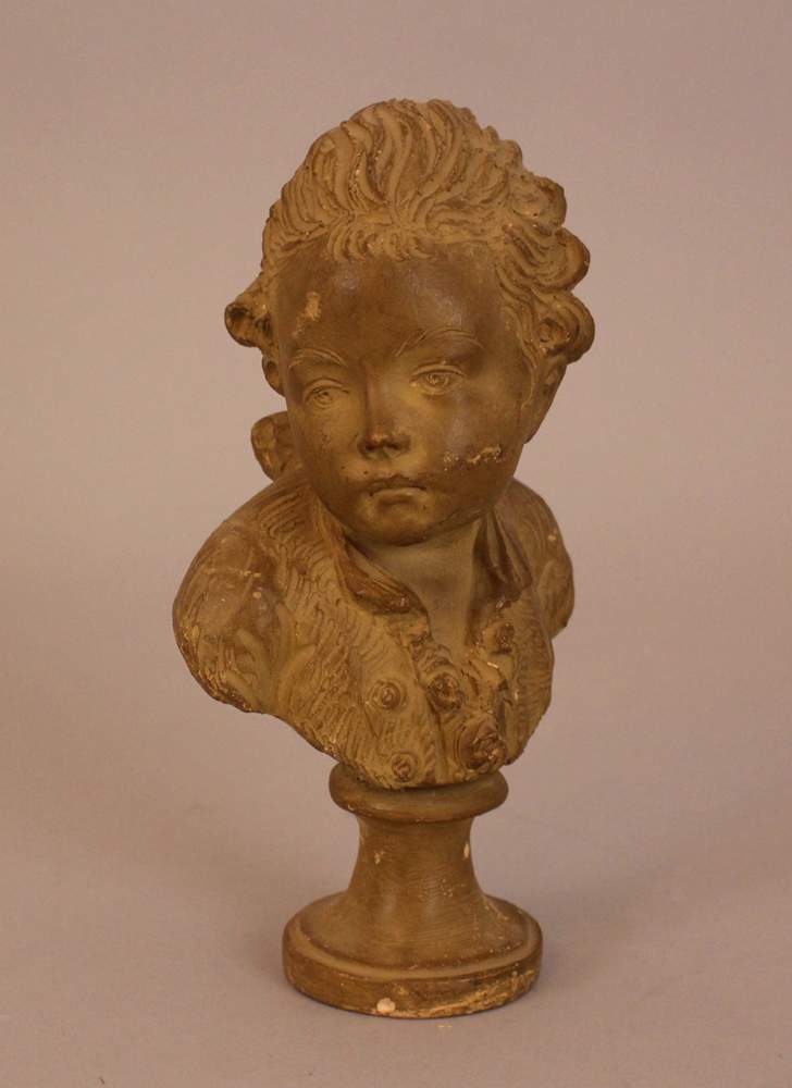 French terracotta bust of a young boy, on integrated round terracotta base and sculpted, with