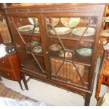 A 1920's Period Carved Mahogany Finish Bookcase, fitted two adjustable shelves, enclosed by a pair