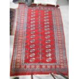 A Persian Red and White Ground Bokhara Rug, with elephant's foot ghul decoration. 74in x 48in.