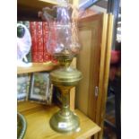 A Brass Oil Lamp with Chimney & Ruby Glass Shade.