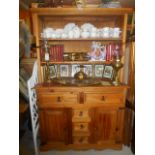 A Pine Kitchen Dresser with two deep shelves over an open section and an assortment of drawers and