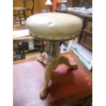 A Victorian Carved Walnut Revolving Piano Stool with circular seat, standing on a turned pillar