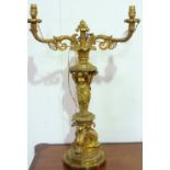 A BRASS TABLE LAMP, THE THREE GRACES WITH ROCOCO DOUBLE BRANCH LIGHTS. HEIGHT 36ins.