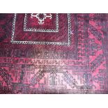 A Persian Style Red Wool Carpet with geometric detail upon a red ground, within further running