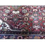 A Red Ground Hand Woven Persian Rug, approx. 6ft 6ins x 4ft 6ins.