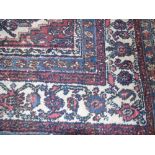 An Eastern Style Wool Carpet with red field, stylised floral detail, set within geometric running