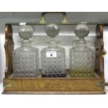 An Oak & Brass Bound Tantalus with Three Decanters.