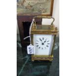 A Brass Carriage Clock, the enamelled dial bearing Roman numerals in original leather case with key,