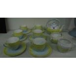 A Miniature Tea Set in Yellow & White Glaze to include a tea pot, six cups and saucers, milk jug and