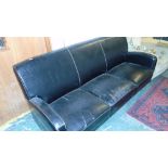 A Black Leather Two Seater Couch.