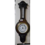 An Aneroid Barometer with an Oak Carved Mount.