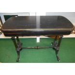 A 19th Century Ebonised Foldover Card Table; with gilded moulding on a turned stretcher base.