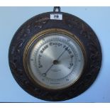 An Aneroid Barometer; on carved Oak mount.