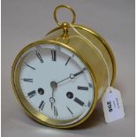 A circular brass clock with enamelled fa
